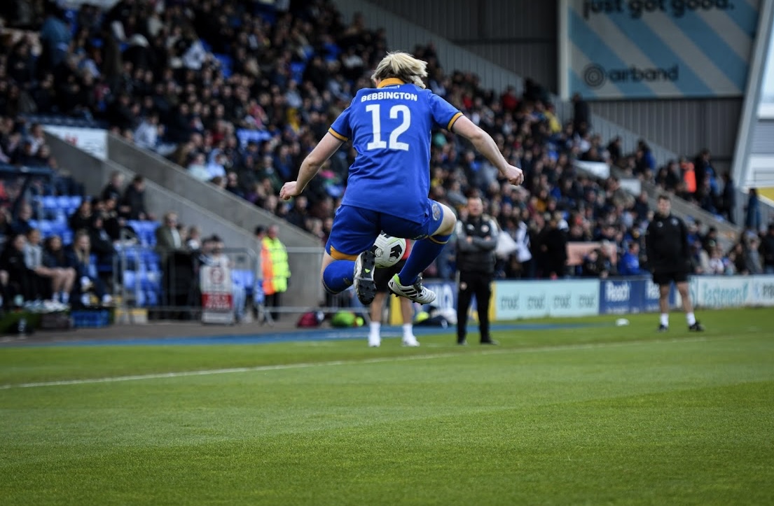 Kim mid-air in a Shrewsbury Town number 12 shirt celebrating during a match