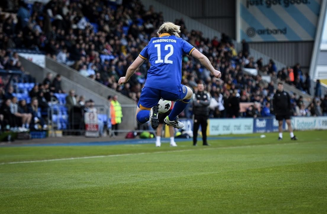 Kim mid-air in a Shrewsbury Town number 12 shirt celebrating during a match