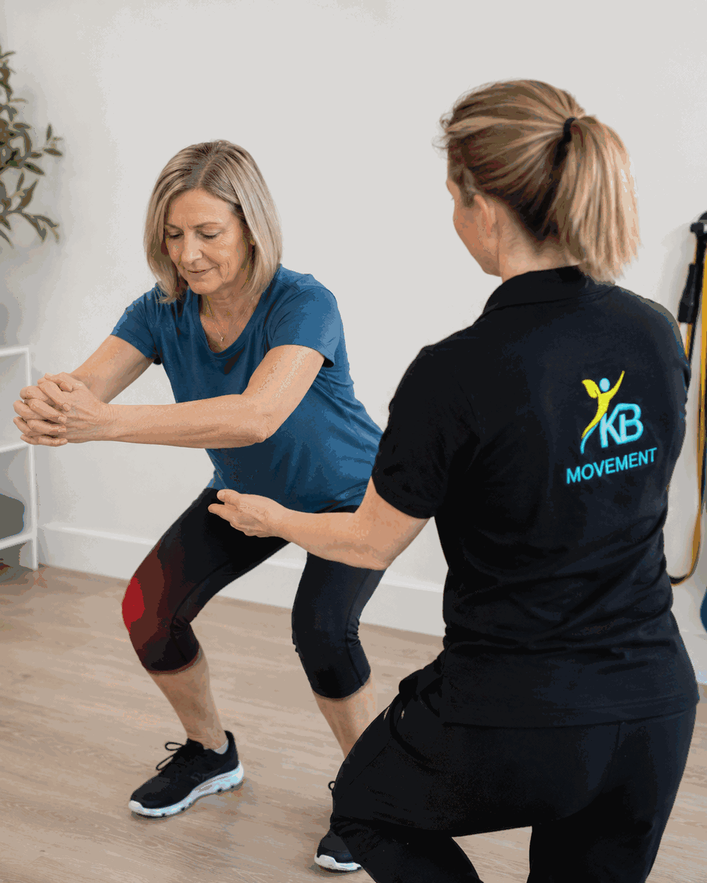 Kim coaching a client through a squat during a movement assessment